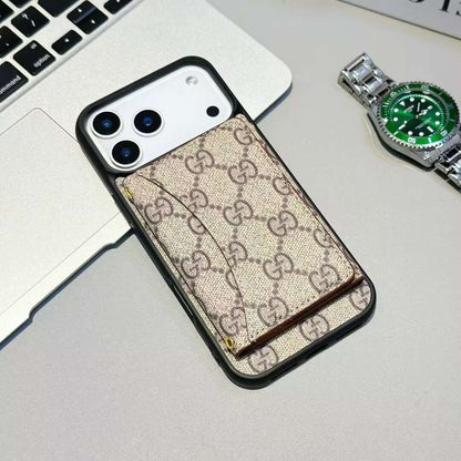 Phone case with Gucci pattern on a desk with a laptop and watch.