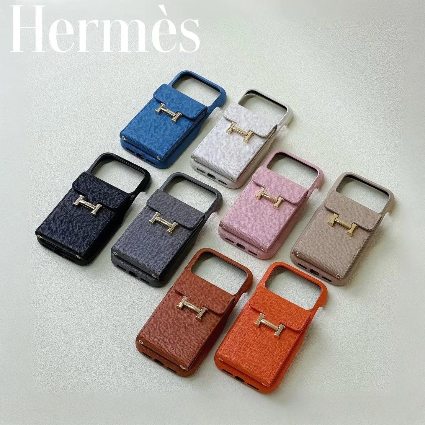 Hermès phone cases in various colors on a light gray background